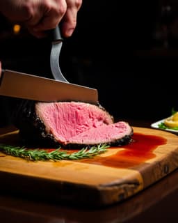 Prime rib being sliced on a wooden board